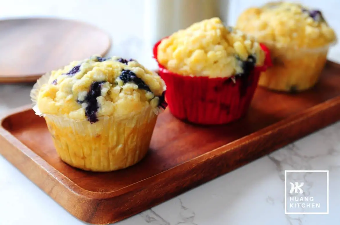 Buttery Blueberry Streusel Muffins Recipe by Huang Kitchen - close up view of muffins with latter in the background